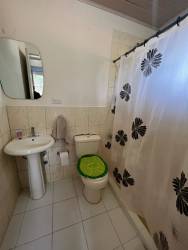 Bright bedroom with turquoise bedding, window and AC in Rancho Los Sueños house for sale Panama