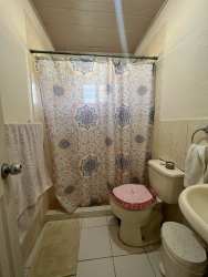 Bedroom with window, ceiling fan, pink bedding in Rancho Los Sueños house in Chame Panama