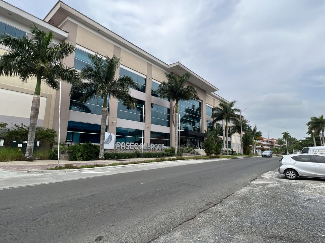 Modern commercial building glass windows palm trees facade Paseo Albrook Panama