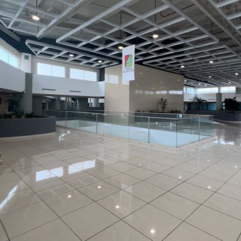 Shopping mall upper floor corridor glass railing and sunlight at Paseo Albrook Panama