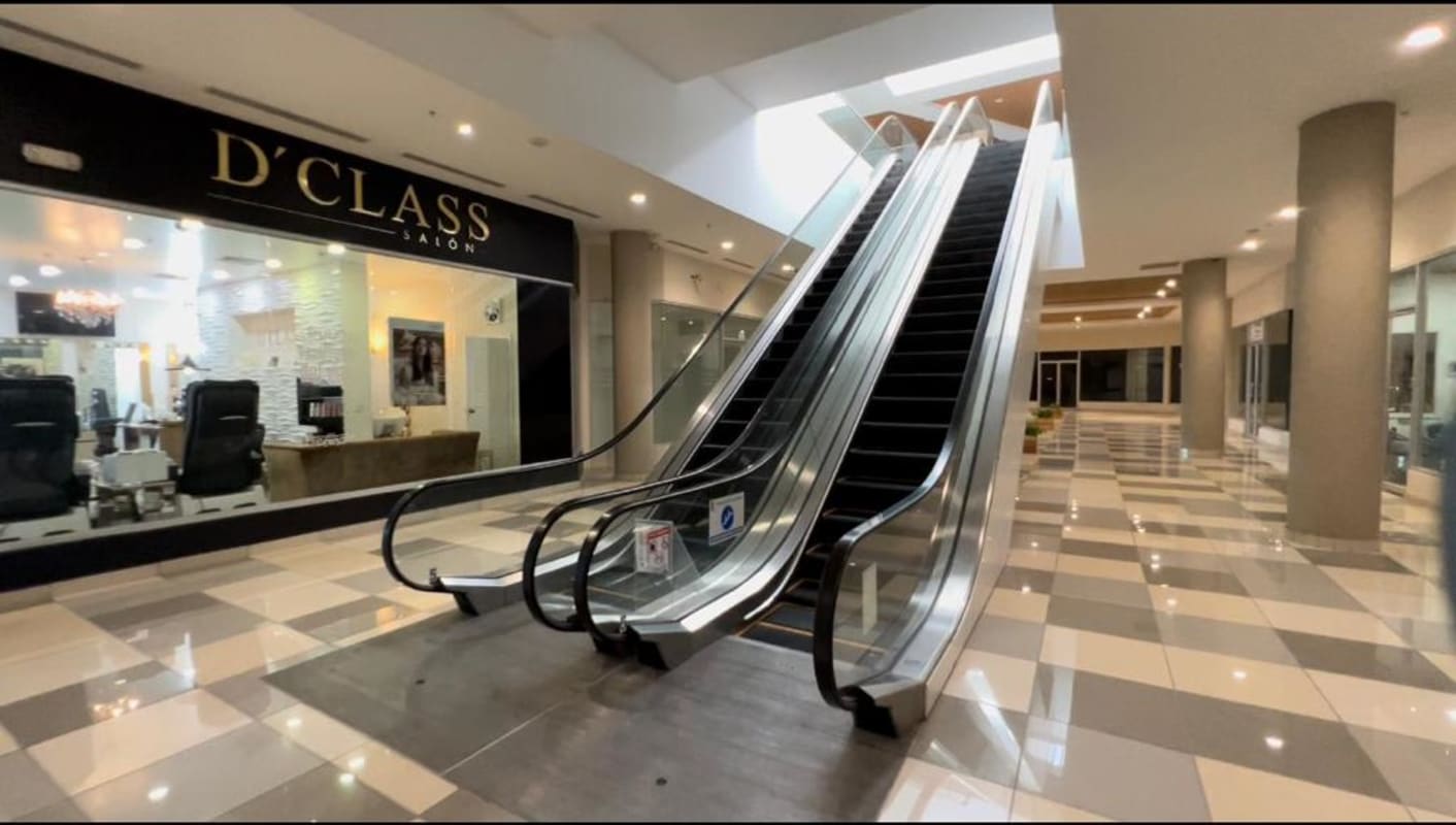 Mall corridor view escalators storefront salons inside Paseo Albrook Panama City