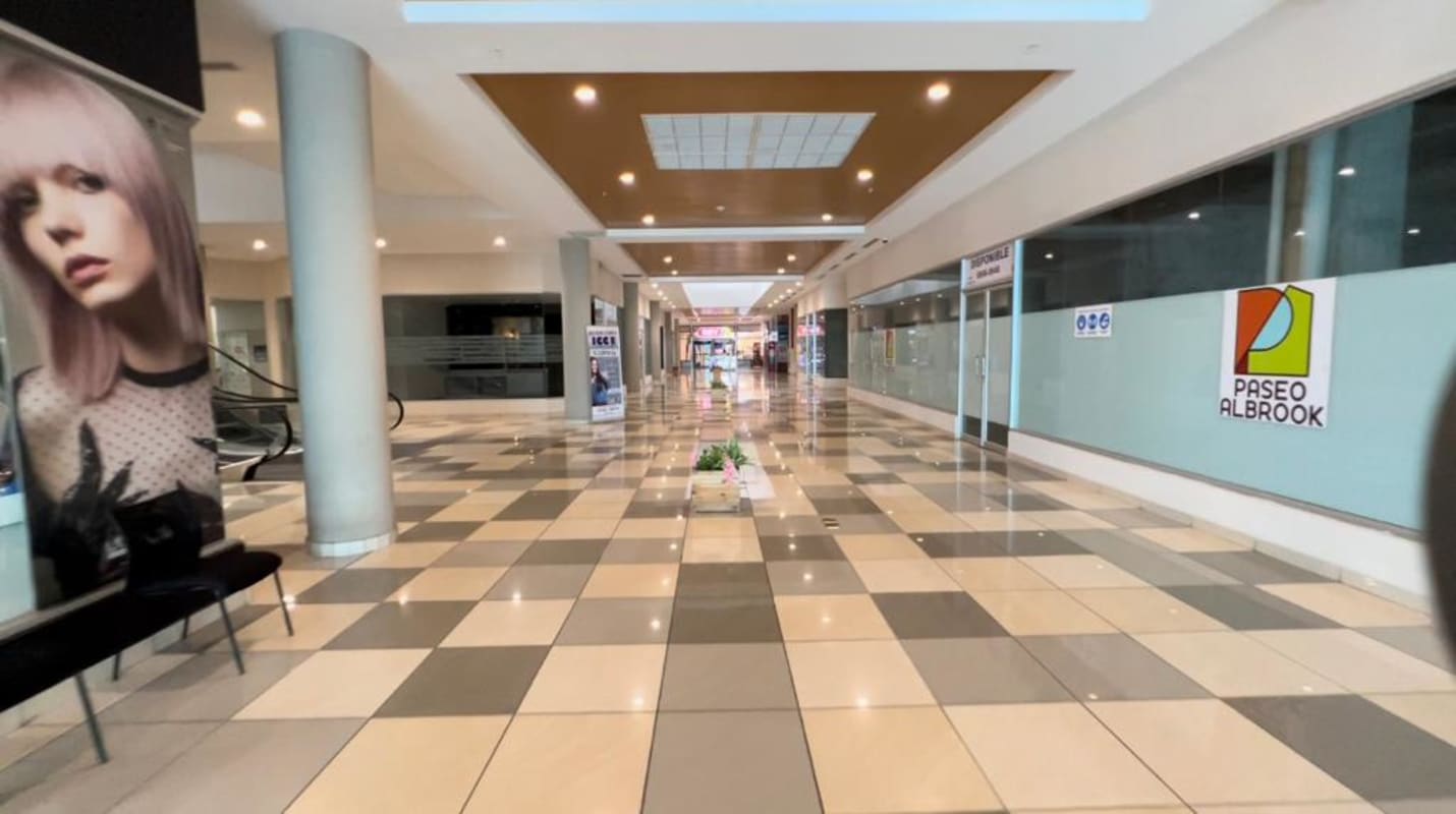 Bright corridor with skylight and retail storefronts in Albrook Mall Panama