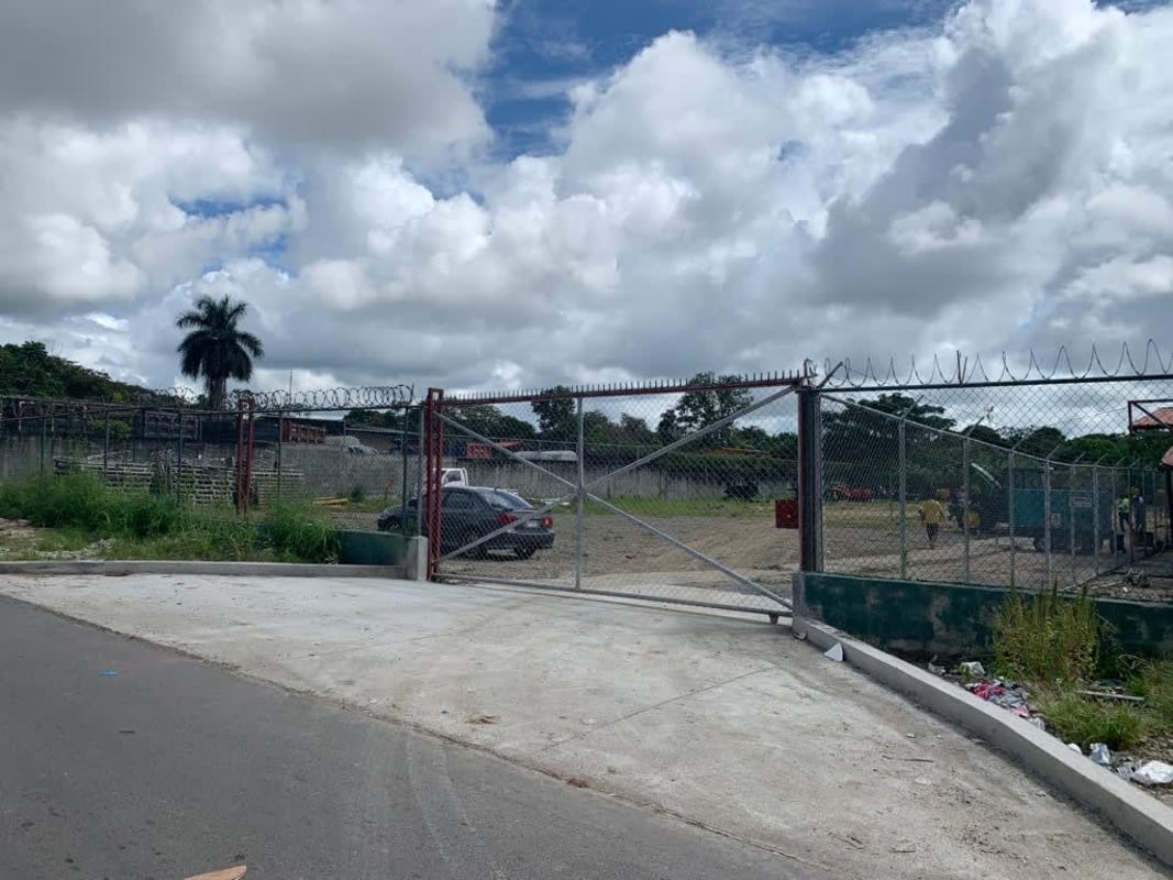 Fenced commercial industrial property lot with single-story office building and wide access road in Mañanitas Panama City