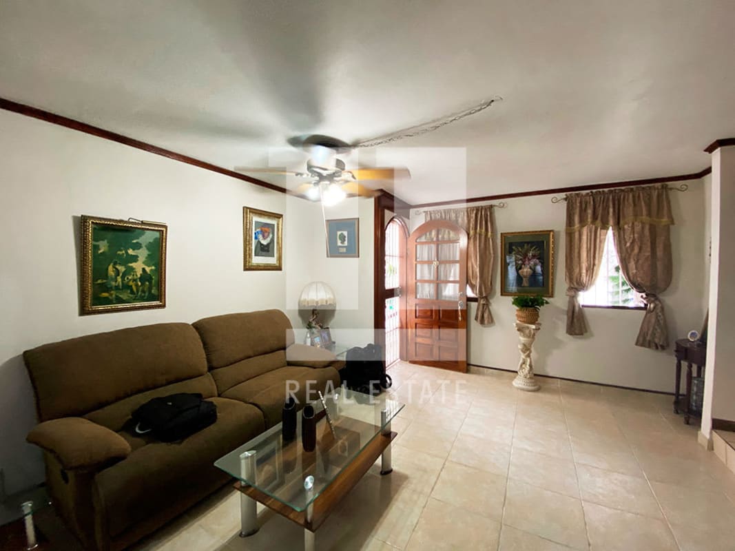 Living room with brown sofas, ceiling fan, tile floor in family house Altos de Panamá Panama City