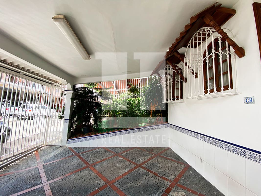 Covered garage with tile floor, security gate and colonial-style windows Condado del Rey house