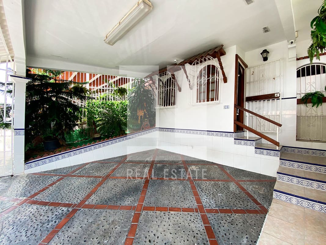 Covered porch with tiled floor, garden plants, white walls in Condado del Rey house for sale