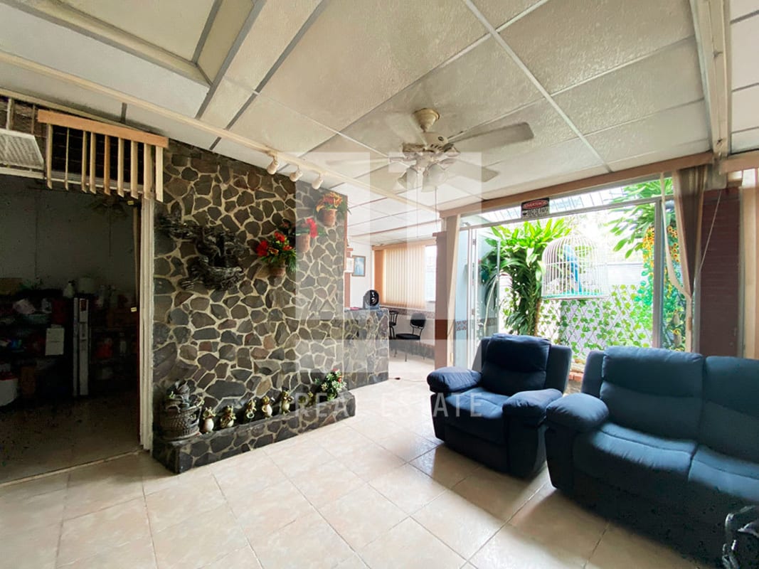 Living room with stone accent wall, blue sofas, garden door in Panama home
