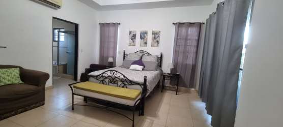 Large bedroom with ensuite bathroom, air conditioning, twin windows with curtains in Hacienda Pacifica San Carlos Panama