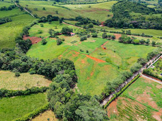 Expansive rural land with clear green fields, boundary fencing, natural vegetation Santa Rita Capira