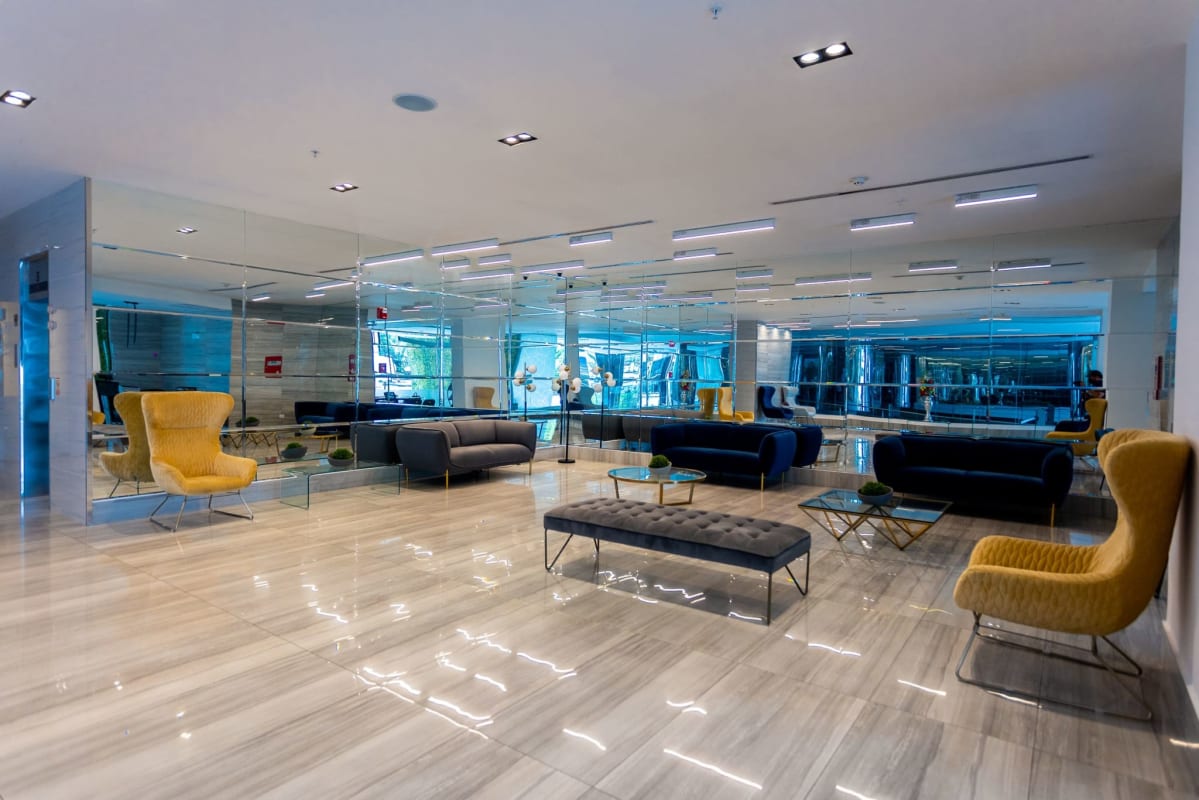 Contemporary lobby with lounge seating, mirrored walls, and reception area in PH Carrasquilla Park Tower Panama