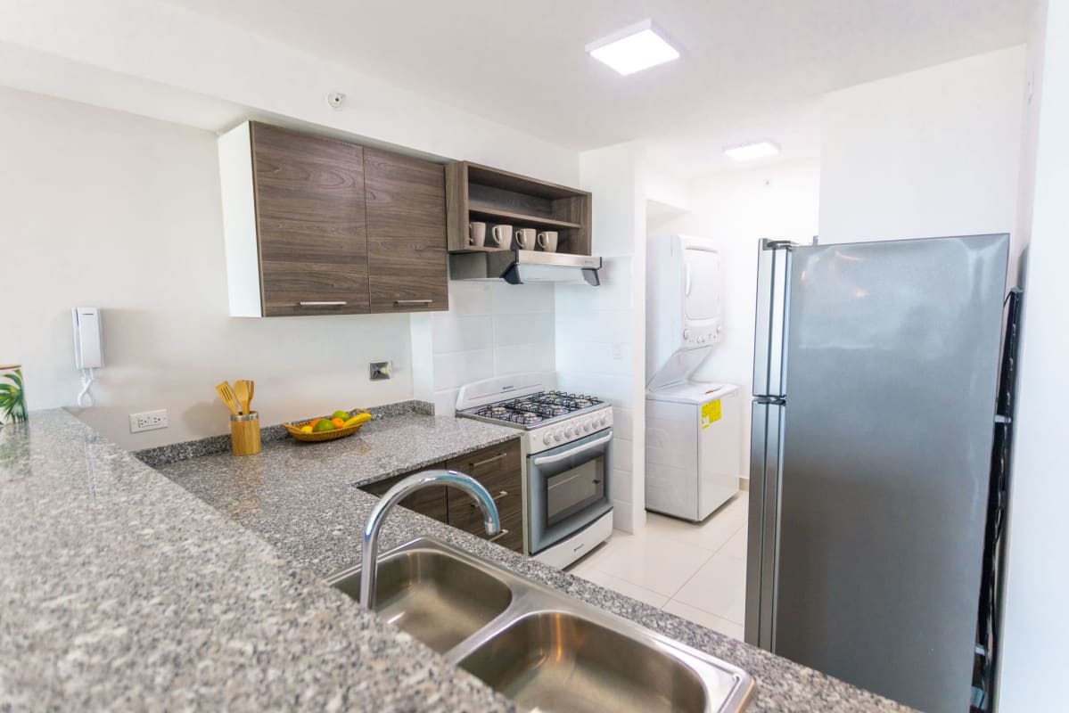 Modern kitchen with granite countertops, appliances space, laundry area in PH Carrasquilla Park Tower Panama City
