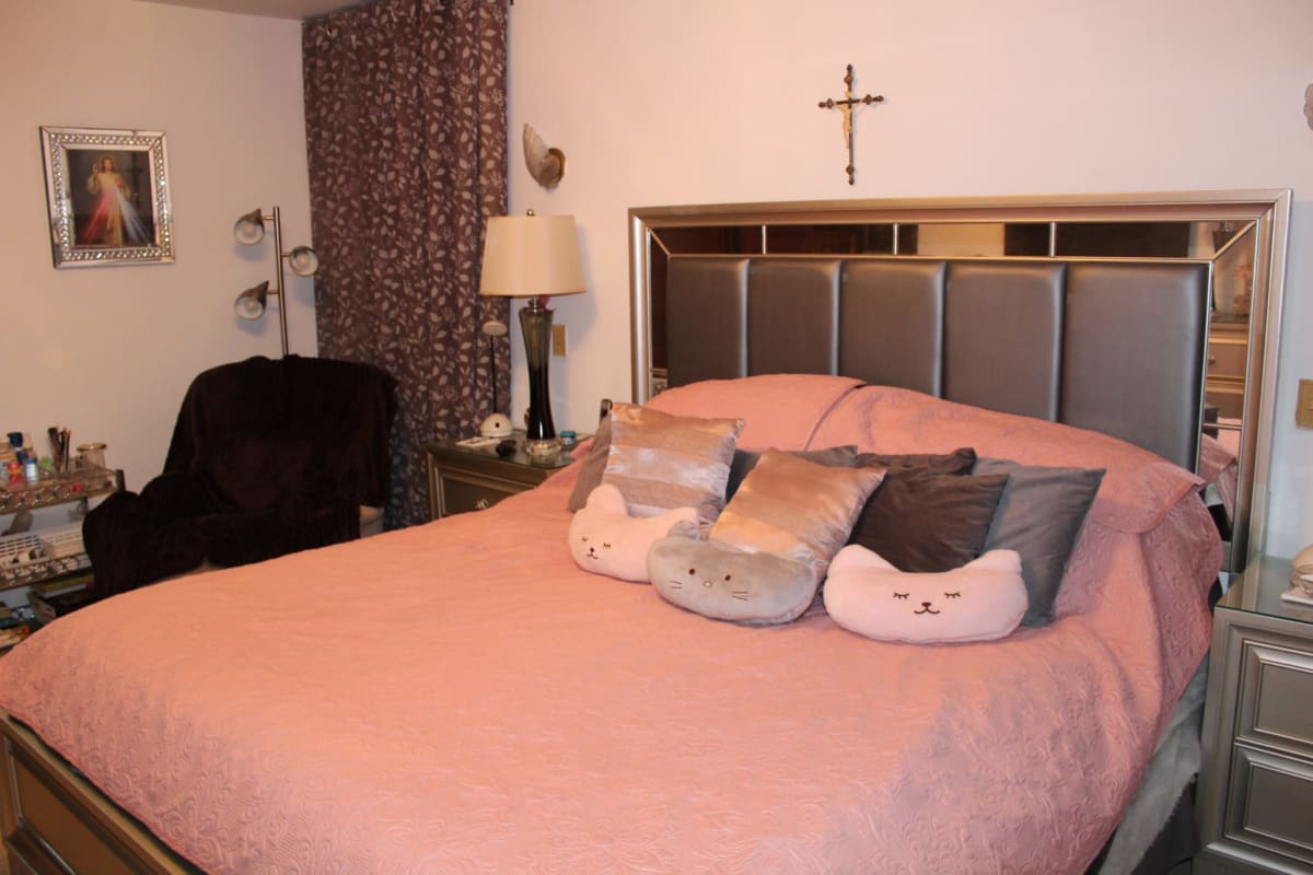 Large bedroom with pink bedding, upholstered headboard, lamps, classic decor in duplex house Hato Pintado Panama City