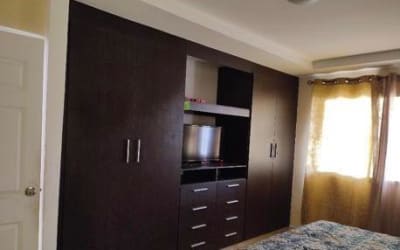 Bedroom with shelving, built-in closet, sunlight entering Colinas del Oeste house Arraiján Panama