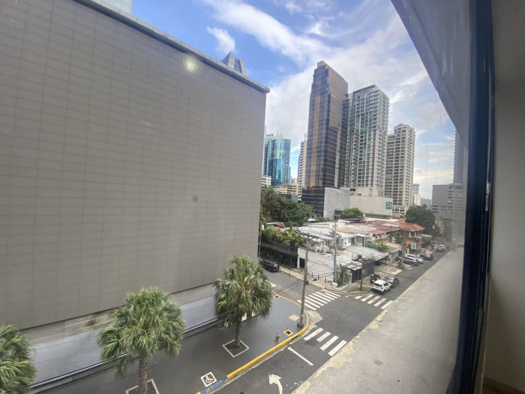 Kitchen with orange cabinetry, tiled walls, black countertops in PH Monaco Panama City Obarrio
