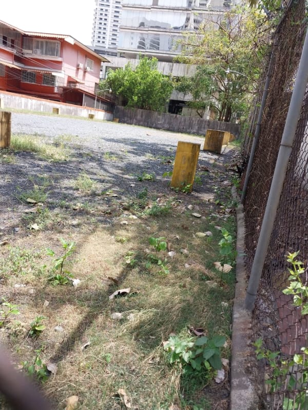 Gravel parking area with fencing adjacent to residential building Via España Obarrio Panama
