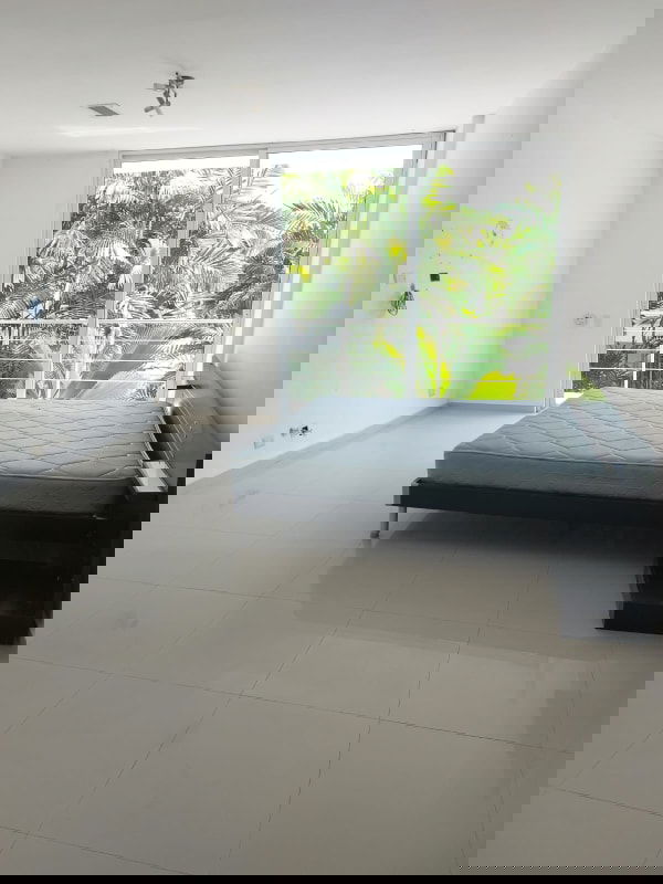 Minimalist bedroom with sliding glass doors to garden in PH Costa Esmeralda Panama City