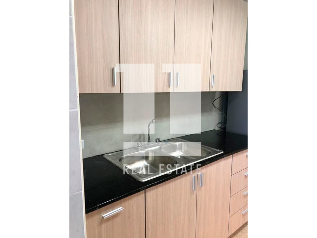 Compact kitchen layout with black granite countertop sink cabinets Panama