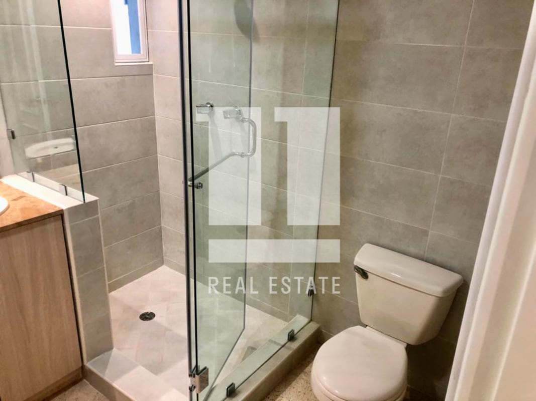 Glass enclosed shower and modern vanity in PH Parque Marbella Panama apartment