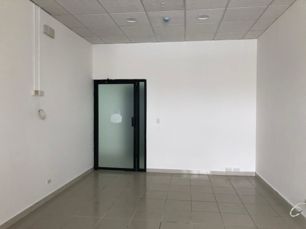 Interior view modern empty office with frosted glass door, recessed lights in The Century Tower Tumba Muerto Panama