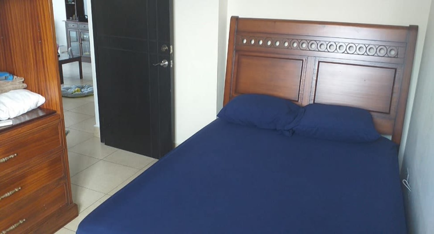 Bedroom with wooden bed frame, blue decor, tiled floor at PH San Francisco 67 Panama