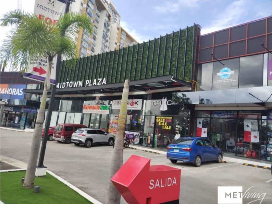 Shopping center exterior with glass storefronts parking palm trees Midtown Plaza Tumba Muerto