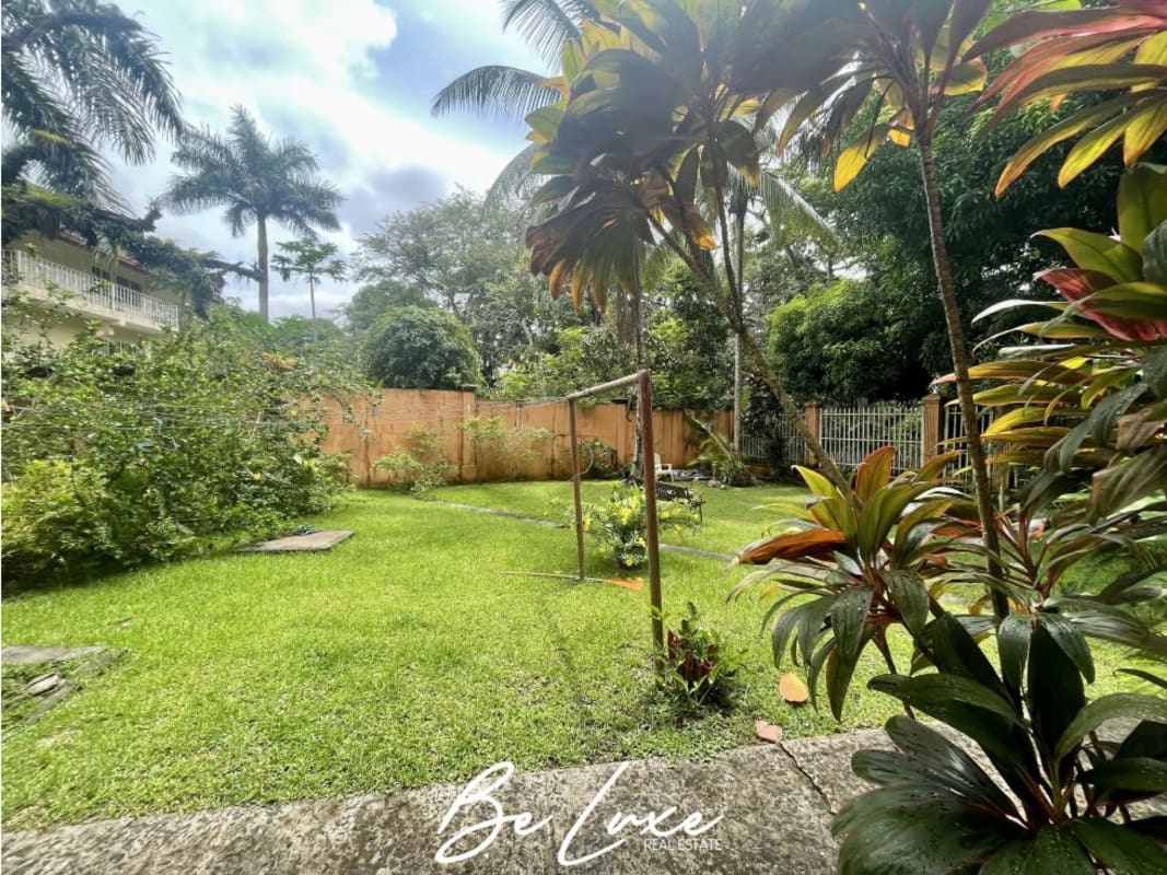 Front facade with arched windows, balcony, lush landscaping of duplex house Albrook Panama