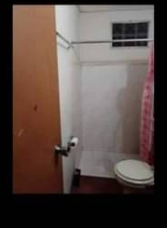 Basic bathroom with toilet sink shower blue fixtures Panama house for sale La Siesta