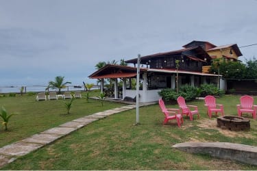 Two-story wooden house facing beach with tropical garden at Viento Frio Panama