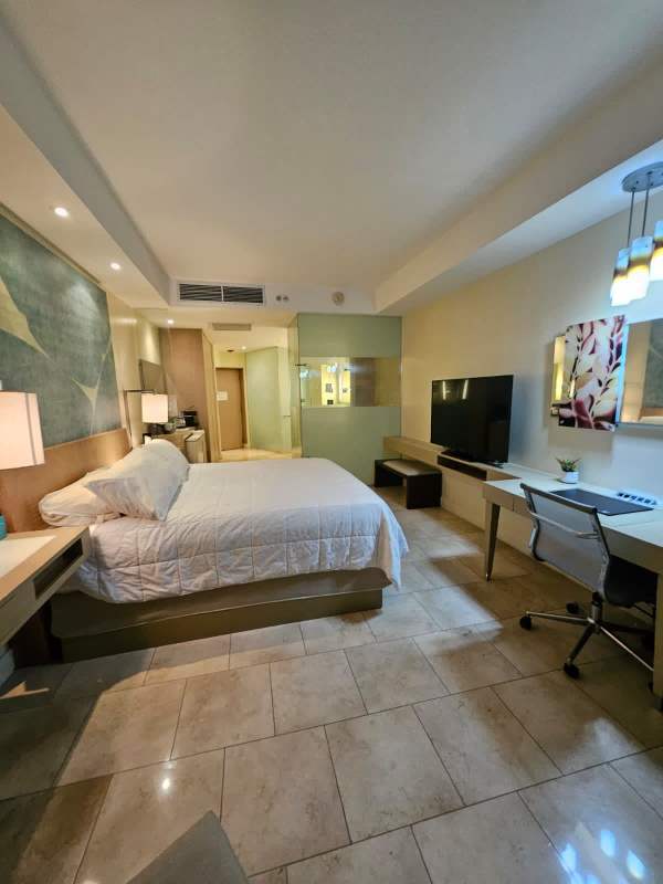 Modern lobby atrium with curved staircase, glass railings in PH The Ocean Club Panama