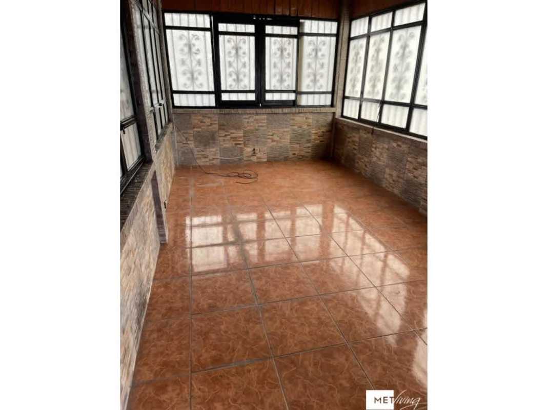 Bright enclosed sunroom with frosted windows, stone wall accents, perfect for relaxing at Cerro Viento home for sale Panama