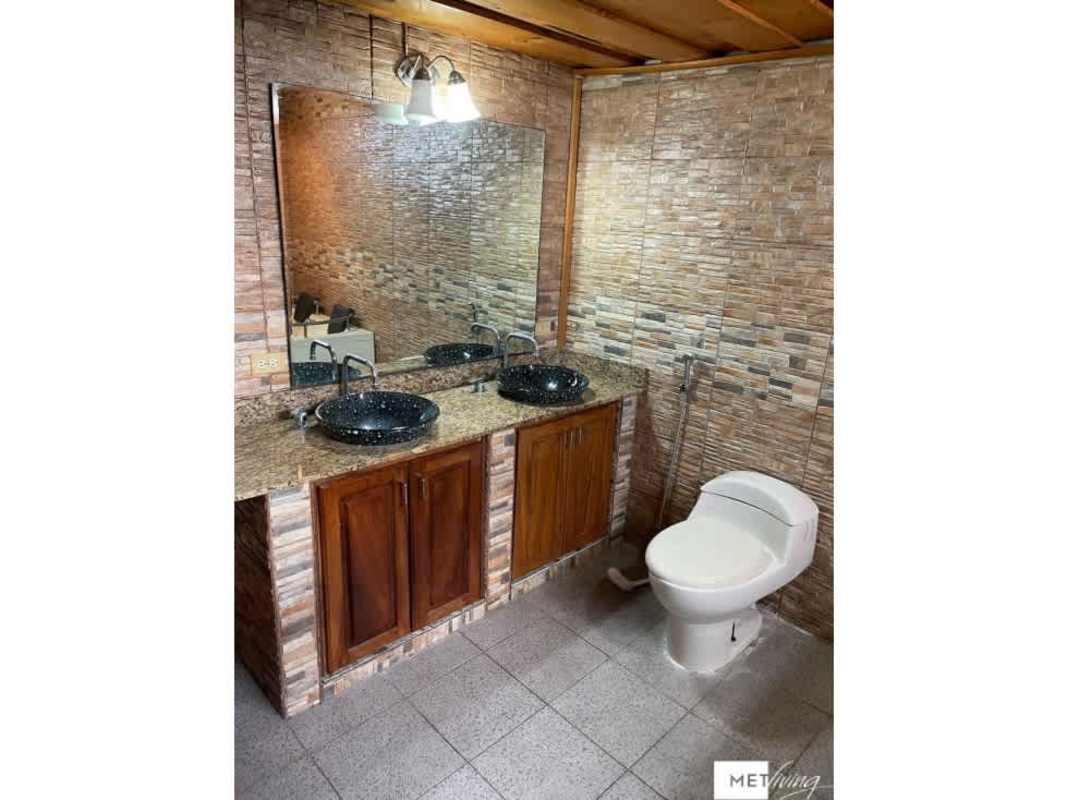 Bathroom with black vessel sinks, granite top, wood cabinets, tile walls Cerro Viento house for sale