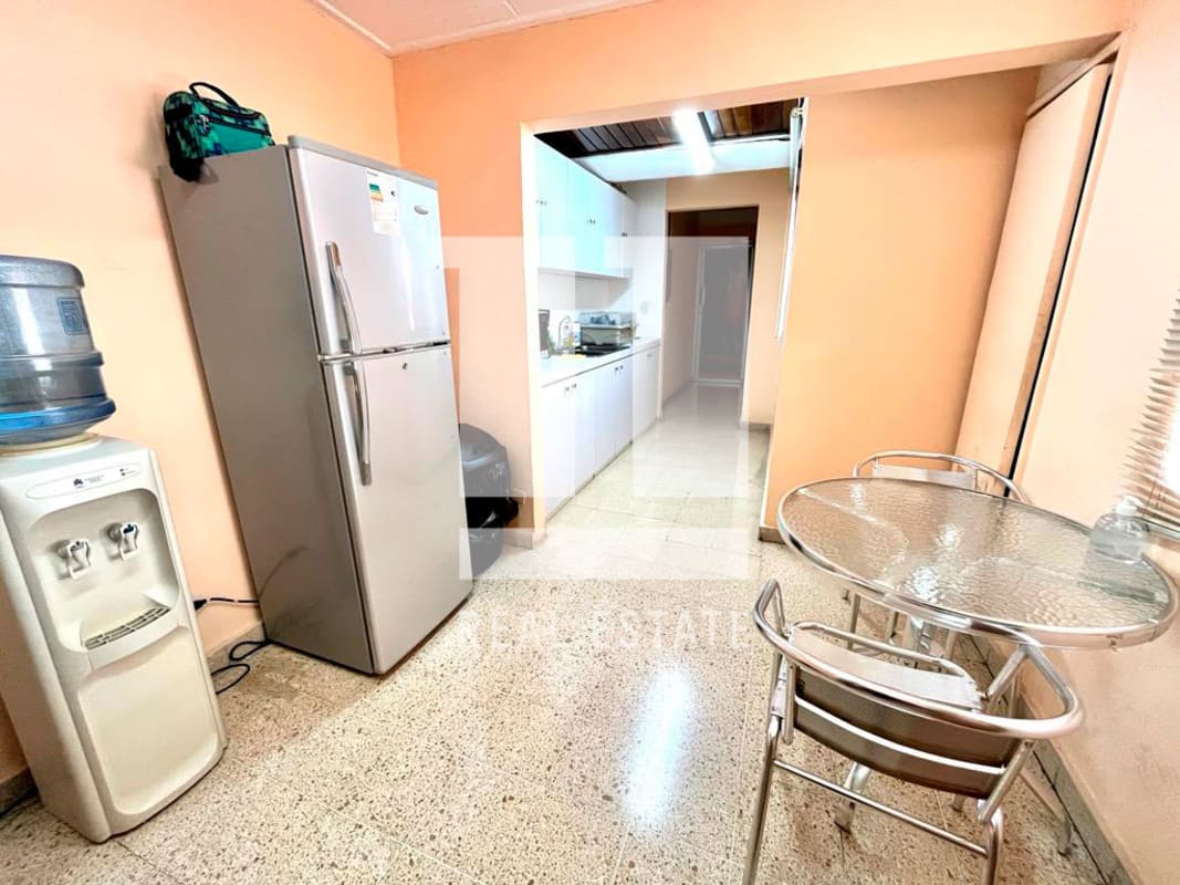 Compact kitchen dining space with peach walls, fridge, table Coco del Mar Panama