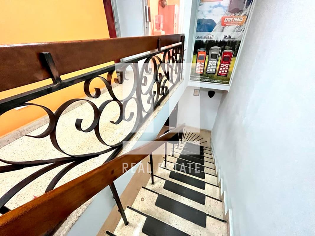Ornate staircase with iron railing and wood handrail inside duplex in Coco del Mar Panama
