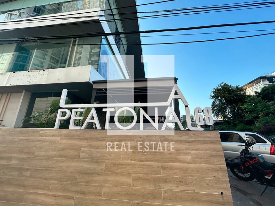 Modern commercial facade with glass windows, wood cladding and 'PEATONAL 68' signage on Vía Porras Panama