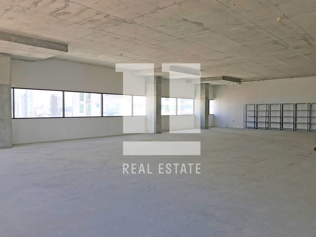 Unfinished commercial space with floor-to-ceiling wraparound windows offering city skyline views in PH Midtown Panama