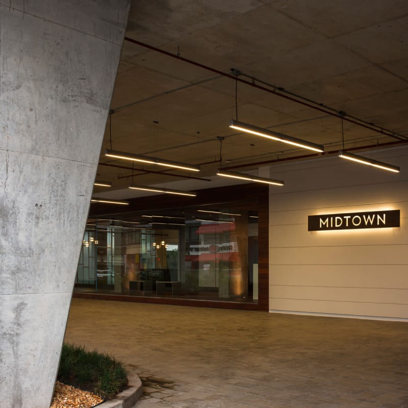 Exterior entrance of PH Midtown commercial tower in Panama City showing illuminated signage and glass wall