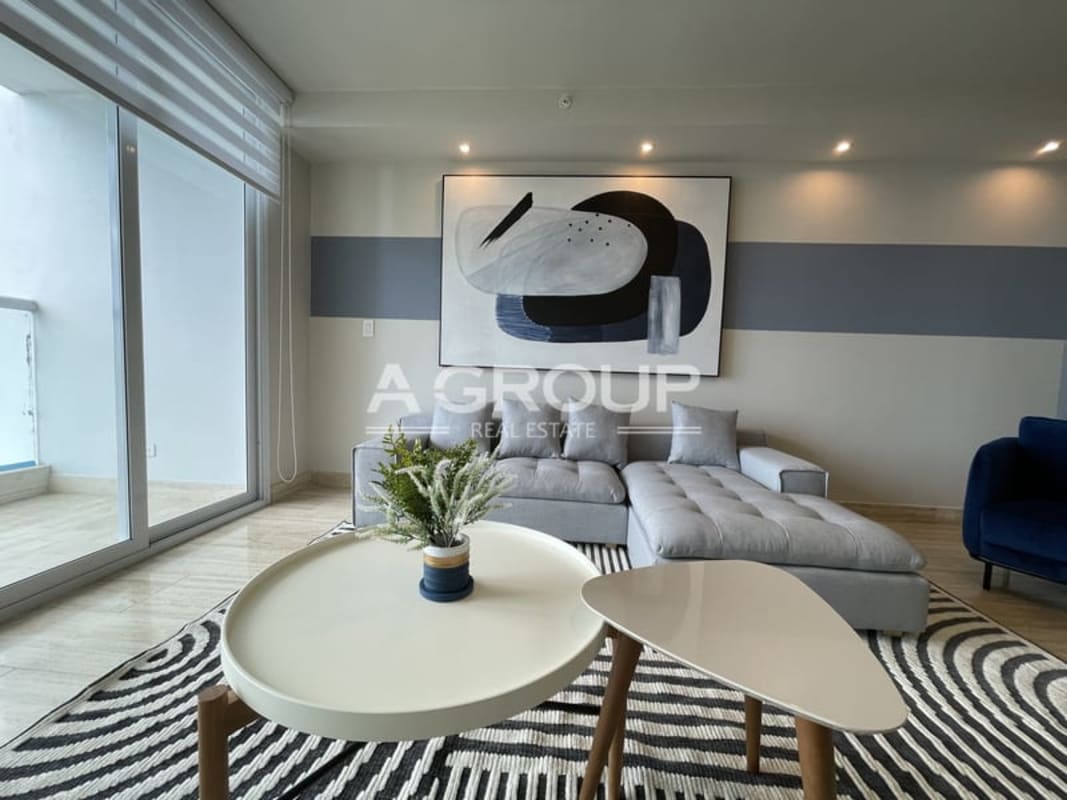 Modern living room with sectional sofa, navy chair, balcony access at The Regent Costa del Este Panama