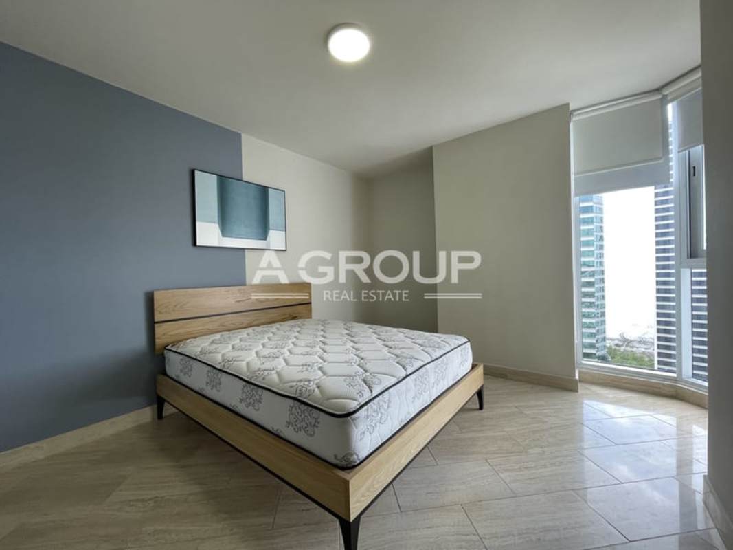 Bedroom with large windows, city view, wood bed frame at The Regent Costa del Este