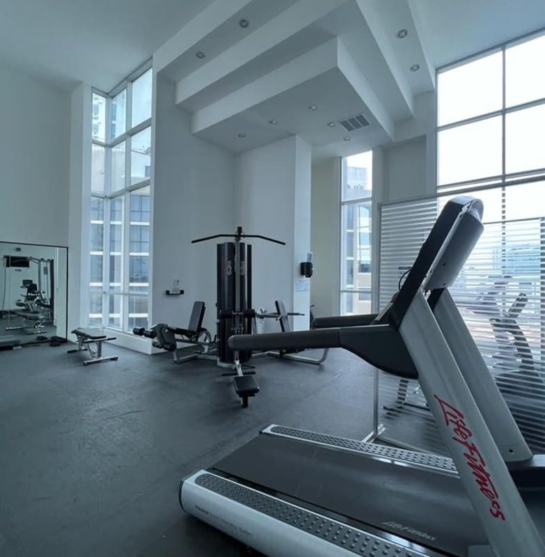 Open living and dining area with city view windows and elegant furnishings PH Waterfalls Panama