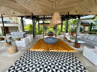 Open-air tropical lounge with sofas wooden table and garden views at Punta Caelo Panama beachfront condo