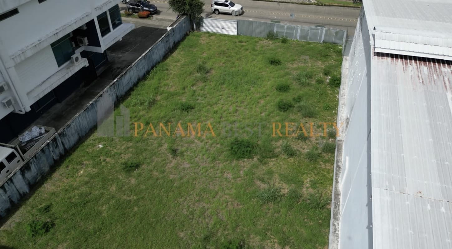 Aerial corner view of fenced commercial lot surrounded by buildings in Costa del Este Panama