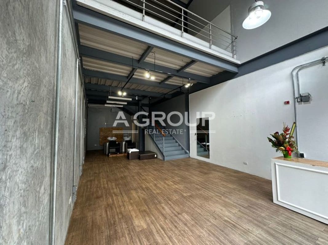 Loft office with mezzanine, concrete walls, wood style flooring and metal staircase in commercial unit at Plaza SF69 Panama City