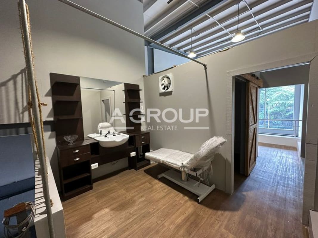 Salon or treatment room with esthetician chair, wall sink, barn door and large window in commercial Plaza SF69 Panama City