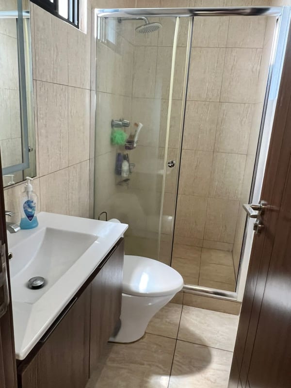 Modern bathroom with tile walls and glass shower enclosure in PH Condado del Rey Panama