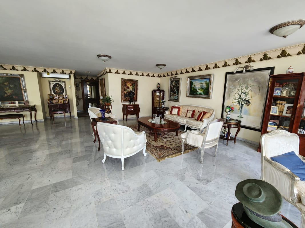 Traditional lounge area with marble flooring, column details, and large windows overlooking Punta Paitilla Panama