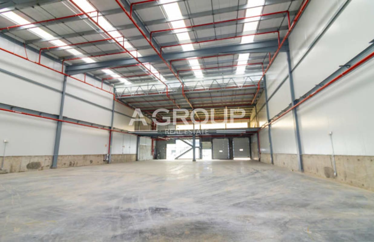 Front exterior view of industrial warehouse with yellow accent, multiple loading bays and parking in Zona Uno Juan Díaz Panama City