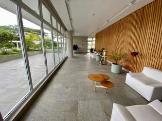 Modern open living and dining room with floor to ceiling windows and ocean views in Solea Punta Barco