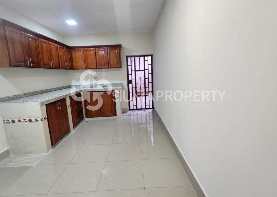Kitchen with wooden cabinets, granite countertops and tiled floors in remodeled home Las Acacias Panama