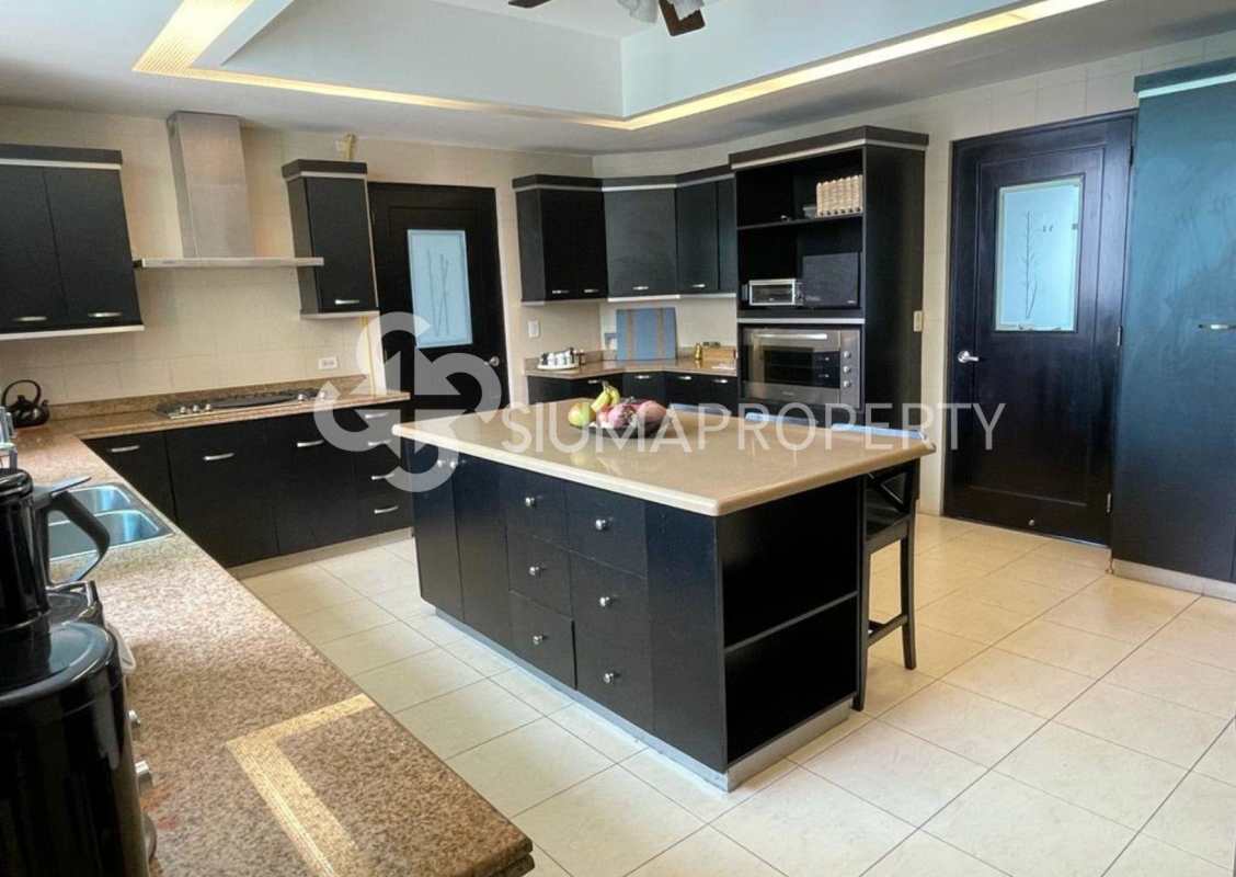 Contemporary kitchen with black cabinetry, granite counters, island, built-in appliances in PH Ocean Park Punta Pacifica Panama