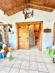 Spacious rustic living room features exposed beams, fireplace, natural light and mountain estate style in Coclé Panama